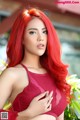 A woman with long red hair posing for a picture.