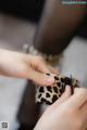 A woman is putting on a leopard print wallet.